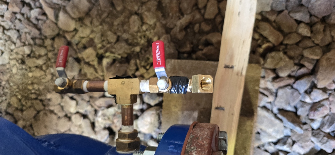 Close-up of a brass pipe fitting and water service connection during installation