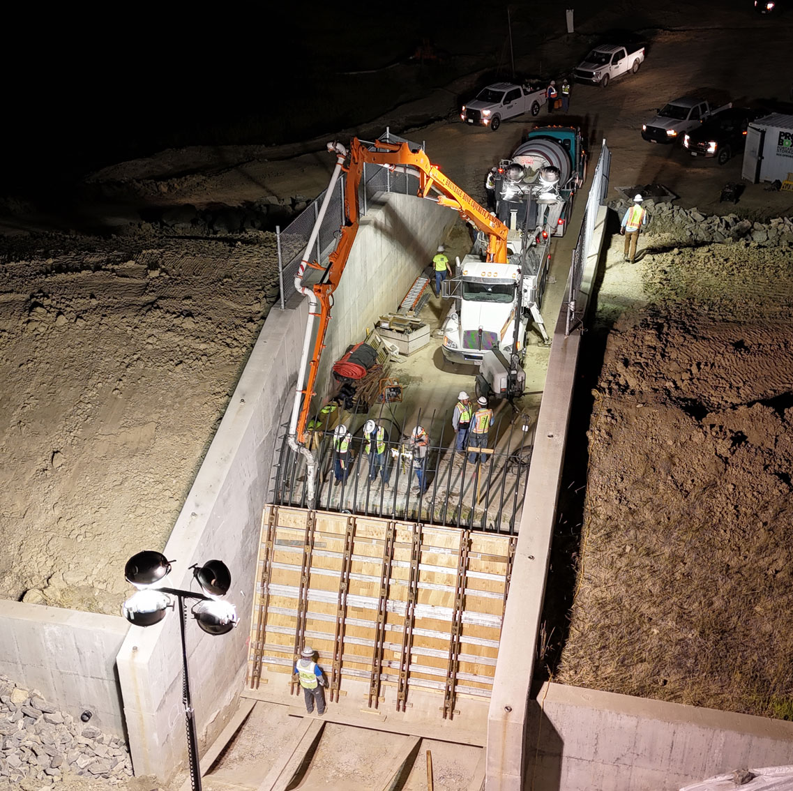 Daytime view of Welton Reservoir expansion showing heavy equipment and rock riprap along the reservoir edge
